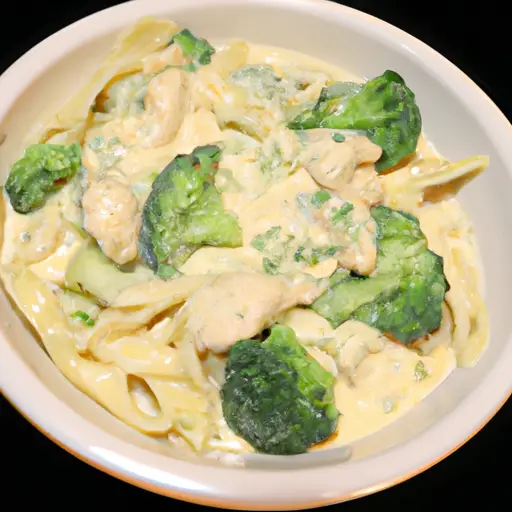 Lizing image showcases a steaming bowl of creamy Chicken and Broccoli Alfredo, as succulent chunks of tender chicken and vibrant broccoli florets are generously coated in a velvety, golden sauce